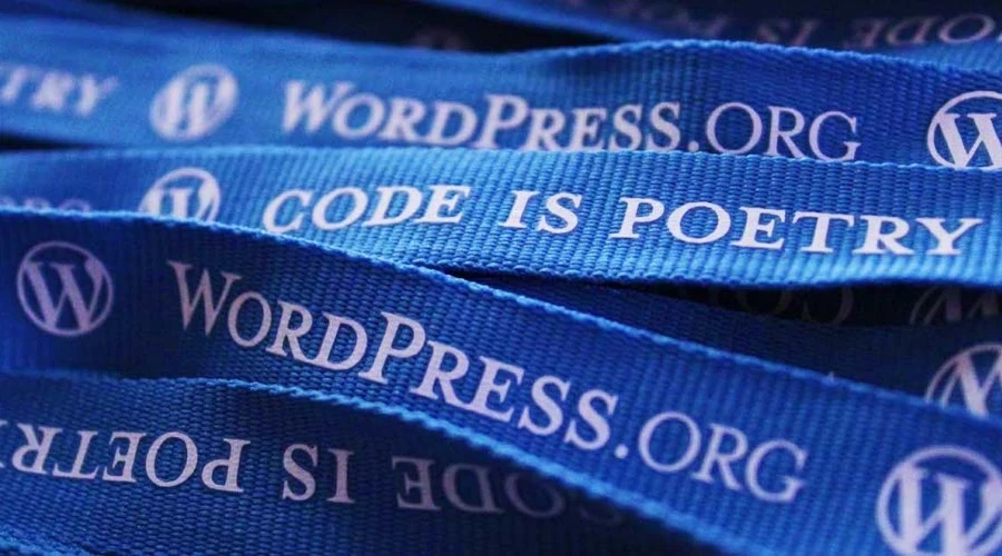 Image mostra várias fitas de crachá com a logo do WordPress e a frase Code is Poetry