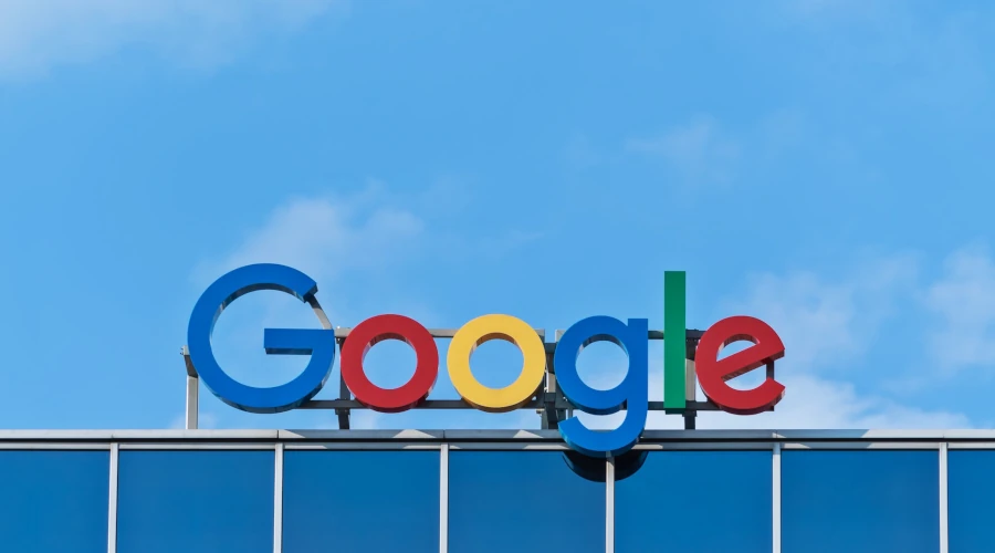 Logo do Google no topo de um prédio com céu azul ao fundo