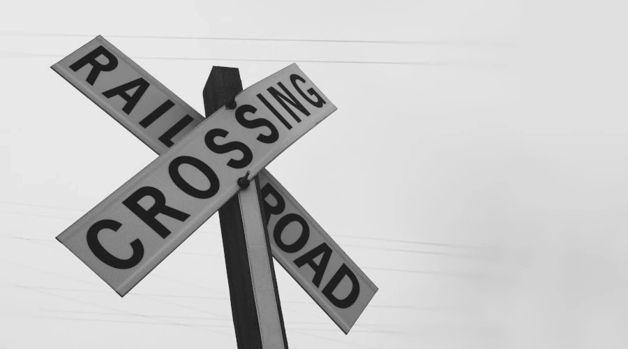 Imagem mostra uma placa de cruzamento de trens