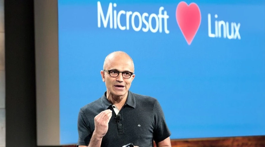 CEO Satya Nadella durante apresentação com tela mostrando Microsoft Loves Linux ao fundo