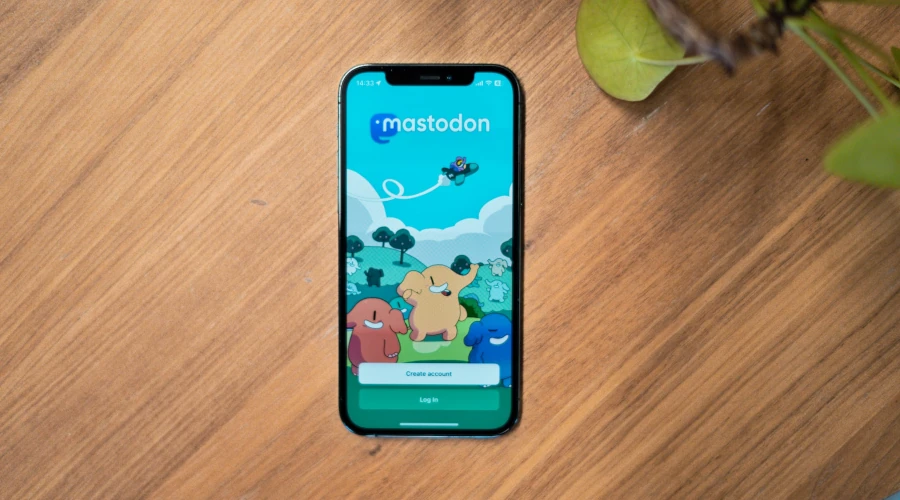 iPhone em uma mesa de madeira com o aplicativo do Mastodon aberto