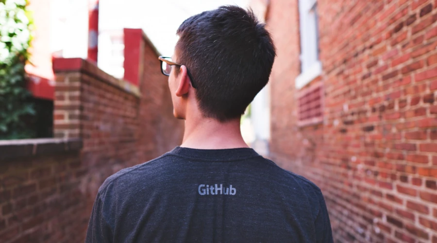 Foto de um homem vestindo uma camisa cinza com a logo do GitHub nas costas