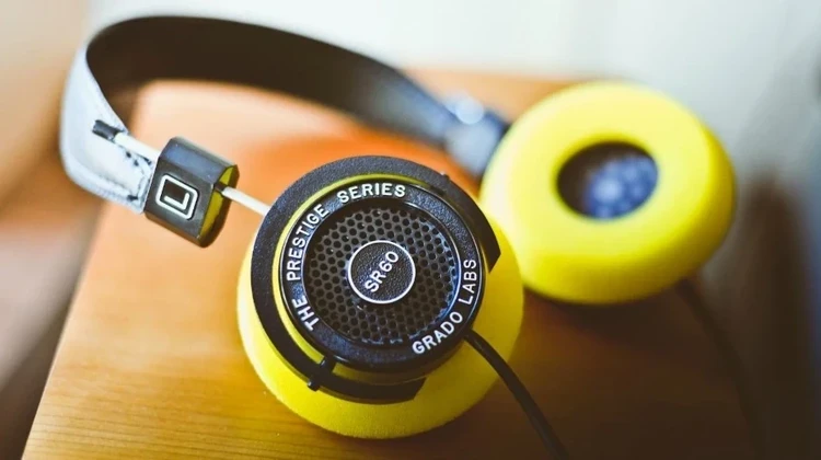 Imagem mostra fones de ouvido amarelos sobre uma plataforma de madeira