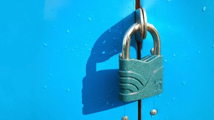 Porta azul claro com um cadeado pesado a trancando